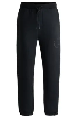 Relaxed-fit tracksuit bottoms with tonal artwork